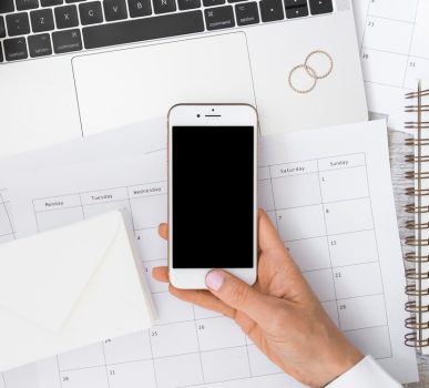 main-homme-affaires-tenant-smartphone-calendrier-enveloppe-ordinateur-portable-alliances_23-2147936746